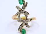 a gold ring with a green stone and diamonds