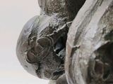 statue of a man holding a ball in his right hand