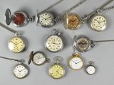 many different types of pocket watches on the table