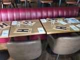 tables and chairs in a restaurant with red booths and wooden tables