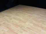 a wooden floor in a room with a black wall