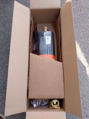 une boîte en carton posée par terre, contenant une bouteille