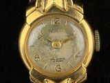 an image of a close up of a wrist watch on a black surface