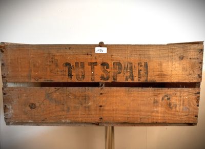 une caisse en bois sur laquelle est accrochée une pancarte portant l'inscription « tutspah »