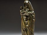 une statue en bronze d'une femme tenant un enfant dans ses bras