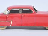 a red toy car that is sitting on a white surface
