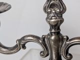 a silver candelab with two candles on top of it