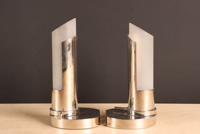 two silver bookends sitting on a wooden table