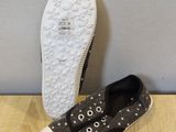 grey and white shoes with stars on them sitting on a wooden floor