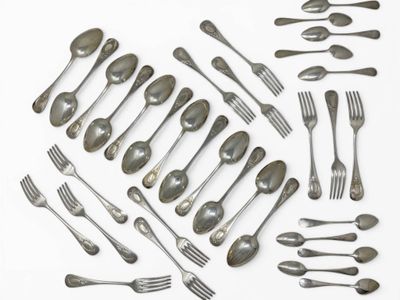 many forks and spoons laid out on a white surface