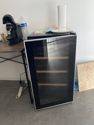 a black and silver wine cooler sitting on the floor