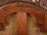 a close up of a wooden bench with a bird perched on top of it
