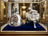 two silver objects in a glass case on a blue surface