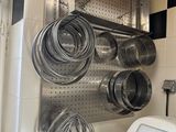 un support mural sur lequel sont rangées des casseroles et des poêles