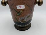 a brown vase with a bird on it on a table