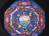 an image of a decorative plate with a fish and flowers on it