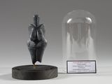 une petite statue représentant une personne, placée sous un dôme en verre