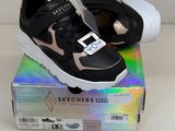 des baskets noires et roses à semelles blanches posées sur une boîte