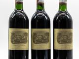 three bottles of wine are lined up on a white surface