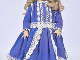 a doll that is wearing a blue dress and hat