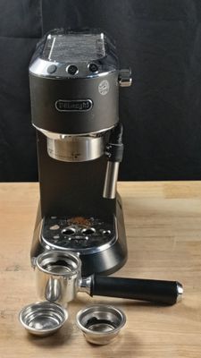 une cafetière posée sur une table en bois, à côté d'une tasse de café