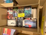 a cardboard box filled with books and dvds