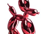 a shiny red balloon dog sculpture on a white surface