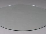 a round mirror on a table with a white table cloth