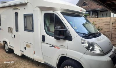 une photo d'un camping-car blanc garé dans une allée