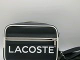 un sac à bandoulière noir et blanc sur lequel est inscrit « Lacoste »