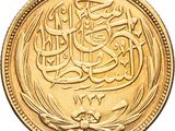 a close up of a gold coin with arabic writing on it