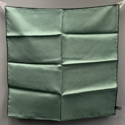 an up close view of a green pillow on a gray wall