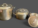 three pots and pans that are sitting next to each other