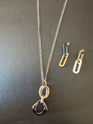 a necklace and earring set on a black leather surface