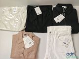 three pairs of men ' s shirts and pants sitting on a table
