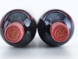 two bottles of wine sitting next to each other on a table