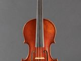 an old violin sitting on a stand against a gray background