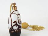 une bouteille en verre blanche et marron avec une poignée dorée
