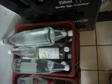 three empty bottles in a red container on a tiled floor