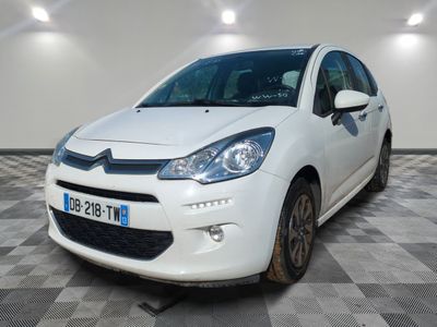 la voiture blanche est garée sur un sol en damier dans le garage