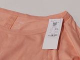pink t - shirt with a tag on it sitting on a white surface