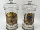 deux bocaux en verre transparent ornés d'un blason et d'un autre blason