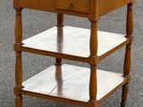 une petite table en bois avec un plateau en verre, posée dans la rue