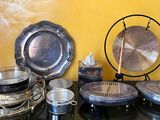 une table sur laquelle sont disposés de nombreux plats et casseroles en argent