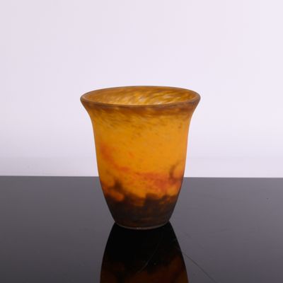 un vase marron et orange posé sur une table noire