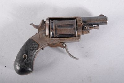un vieux fusil exposé sur une surface blanche