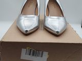 pair of silver shoes sitting on top of a box on a table