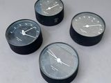 quatre horloges noires et blanches posées sur une table