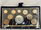 un assortiment de pièces de monnaie dans un étui en plastique posé sur une surface blanche