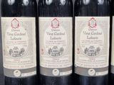 three bottles of red wine are lined up on a table
